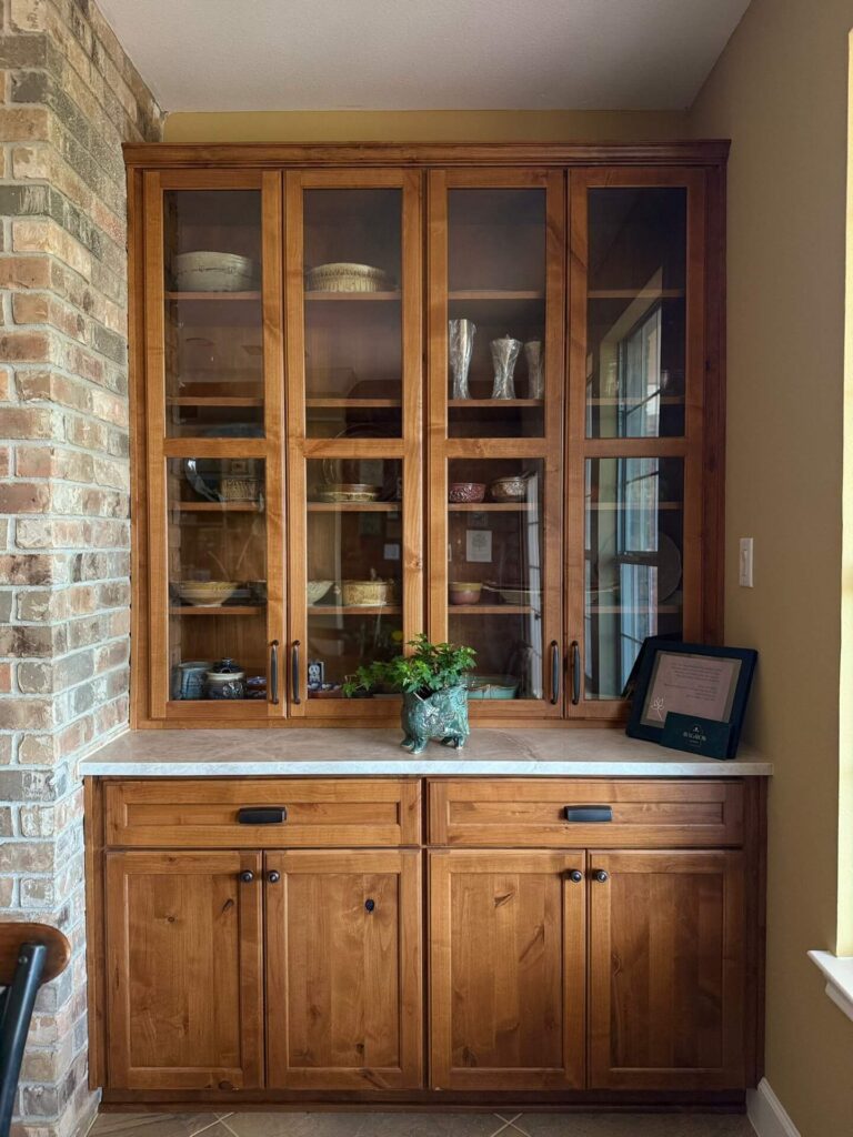 RTA Pearl Glazed Shaker on the perimeter, Durasupreme Knotty Alder on the island and coffee area, Taj Mahal quartzite countertops throughout