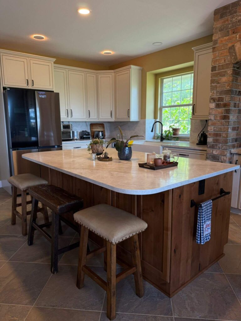 RTA Pearl Glazed Shaker on the perimeter, Durasupreme Knotty Alder on the island and coffee area, Taj Mahal quartzite countertops throughout