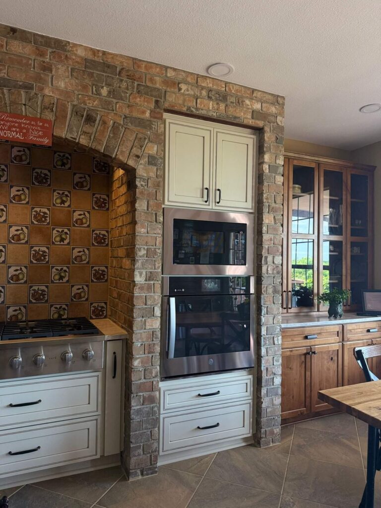 RTA Pearl Glazed Shaker on the perimeter, Durasupreme Knotty Alder on the island and coffee area, Taj Mahal quartzite countertops throughout