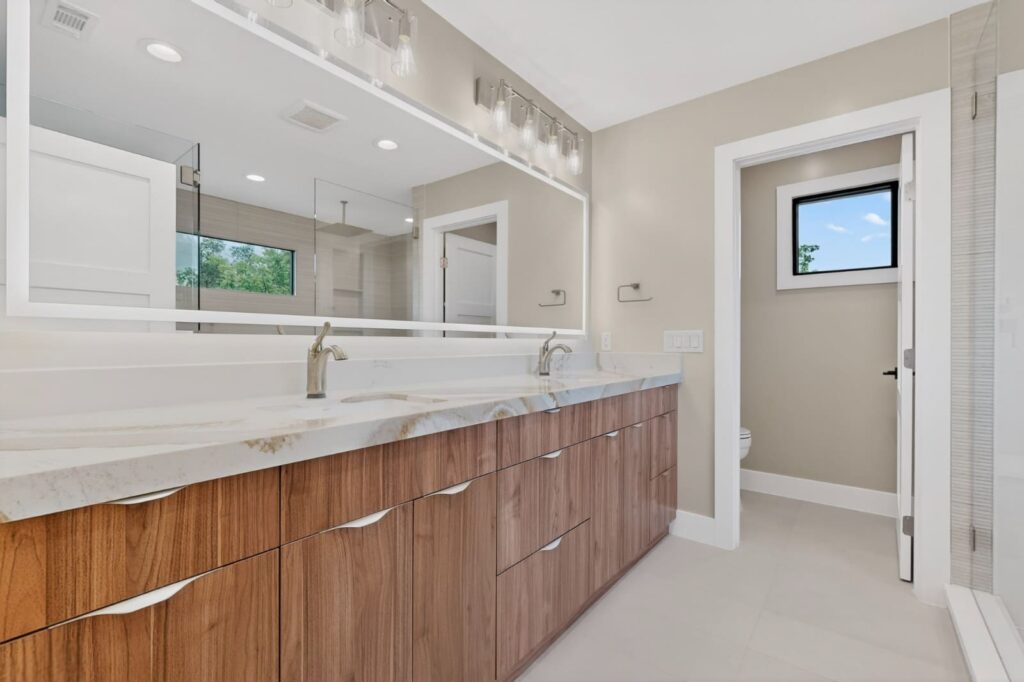 Modern walnut floating vanities in master bathroom by Cabinetto Austin