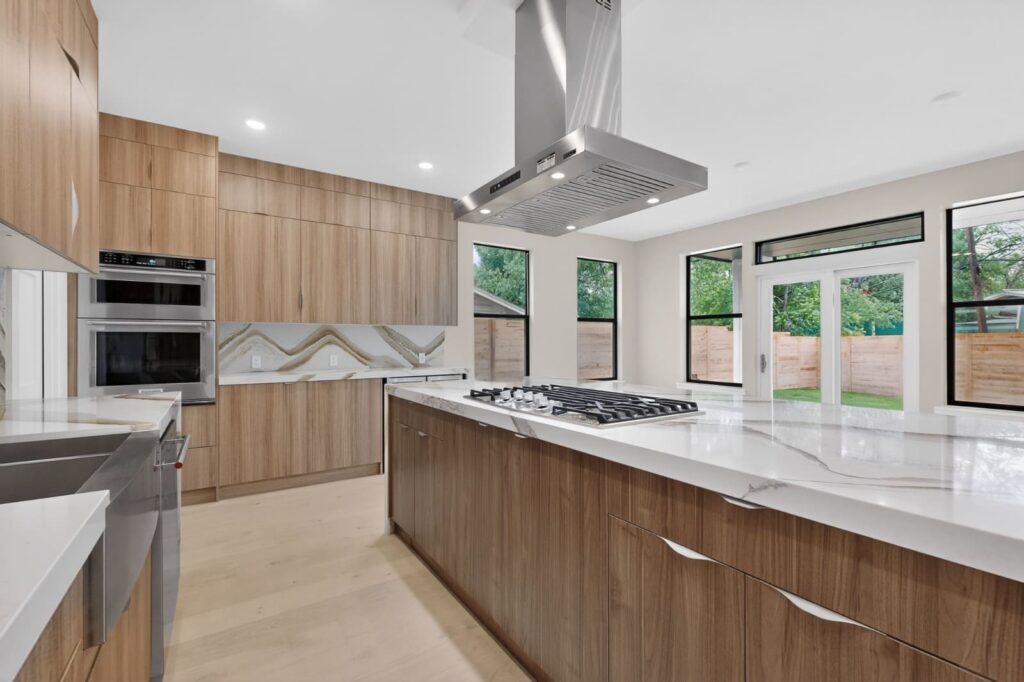 Walnut frameless kitchen cabinets with Cambria Britannica Gold Warm countertops in Austin Texas