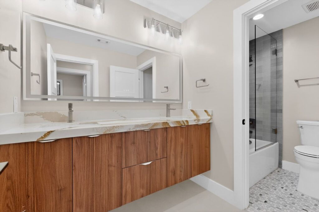 Modern walnut floating vanities in master bathroom by Cabinetto Austin