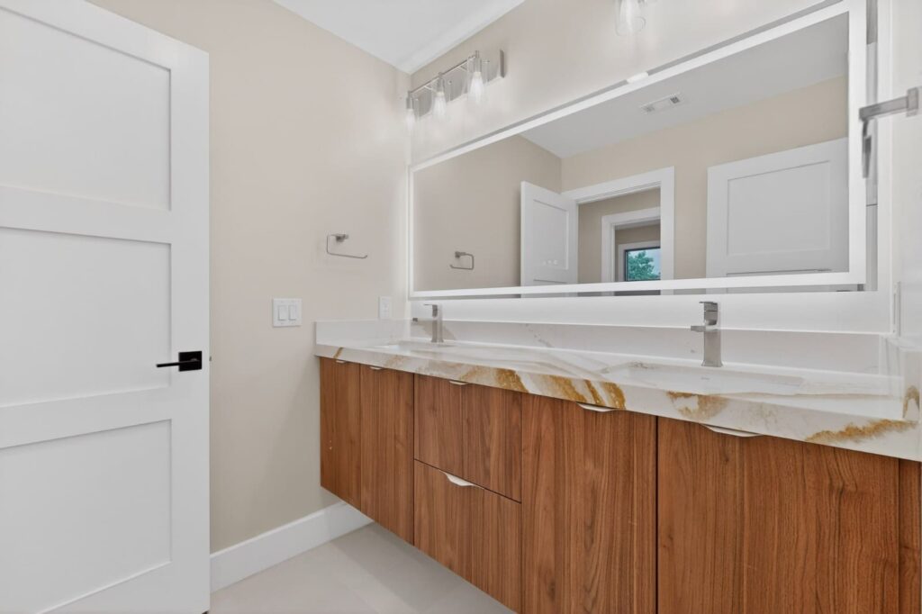 Modern walnut floating vanities in master bathroom by Cabinetto Austin