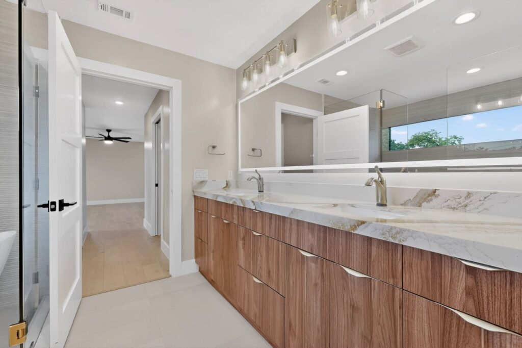 Modern walnut floating vanities in master bathroom by Cabinetto Austin